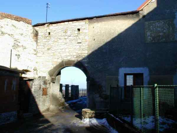 západní hradba s portálem brány a napojením okrouhlé bašty